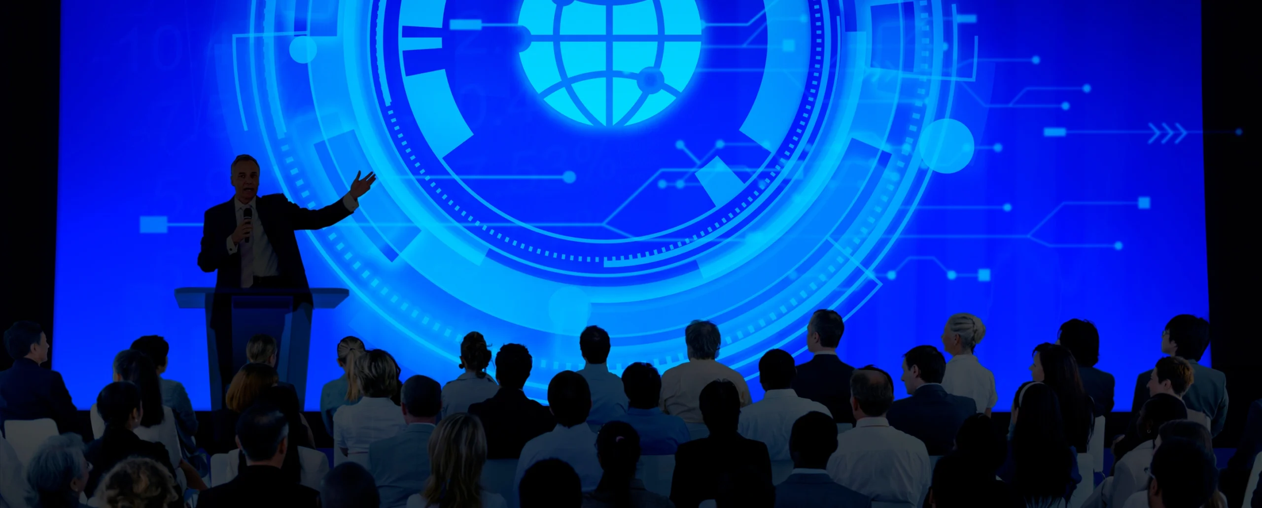 Speaker presenting digital technology to a conference audience.